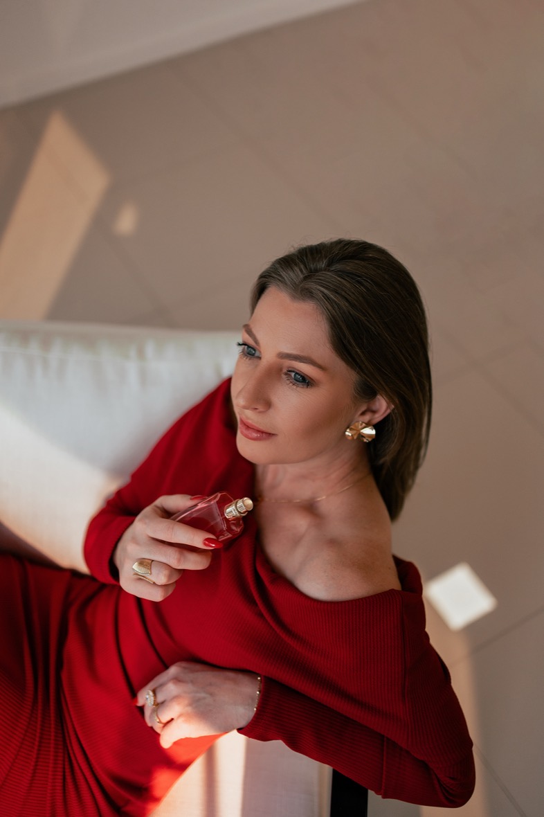 Registro do Patroa Day — mulher de vestido vermelho com perfume.